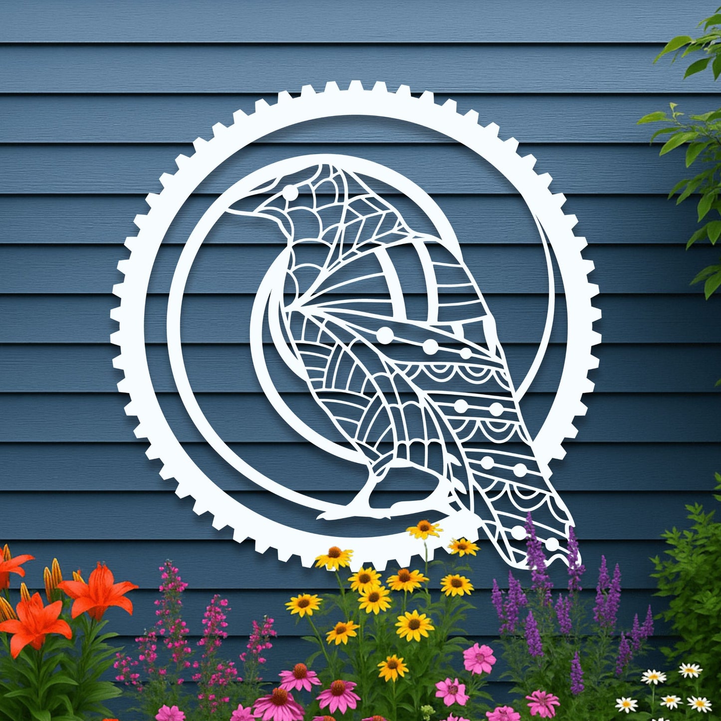 Decorative metal wall art of a stylized bird in a gear on a blue wooden wall with flowers below.