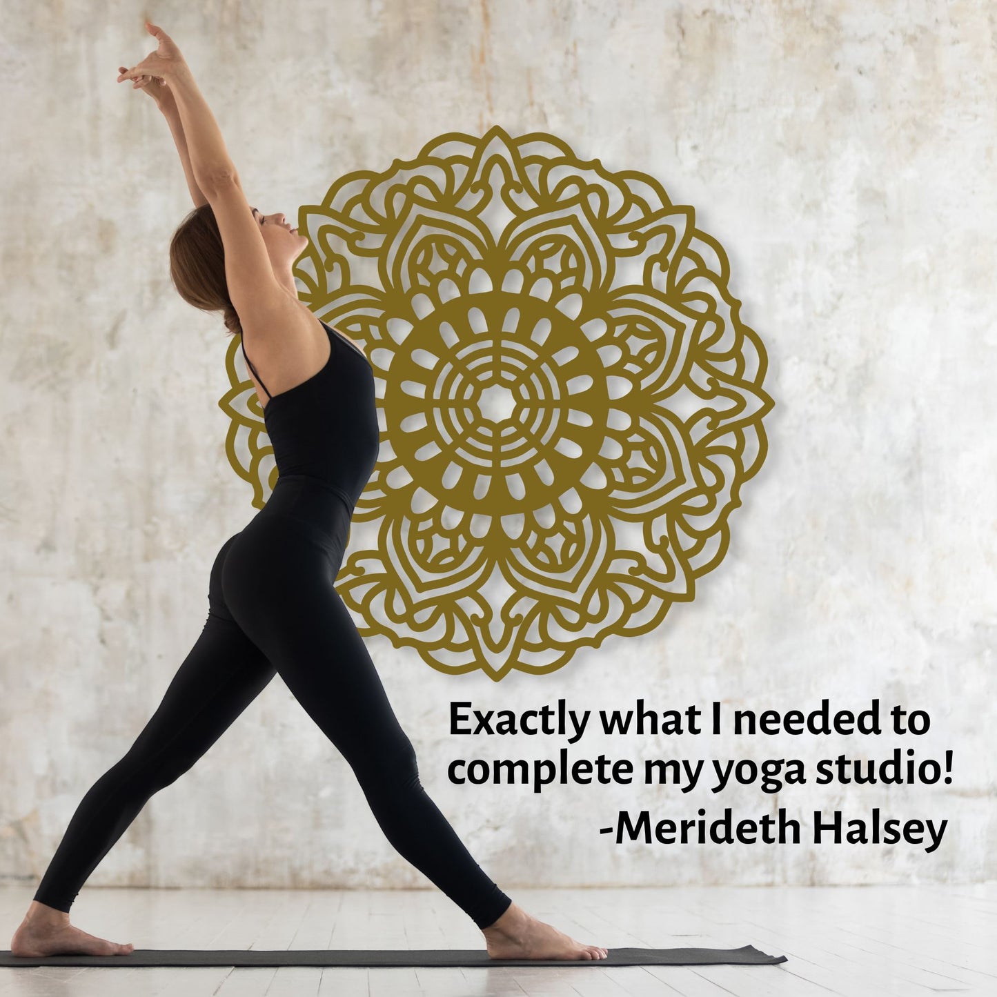 Woman in black yoga attire practicing yoga with a gold mandala wall decal in the background.