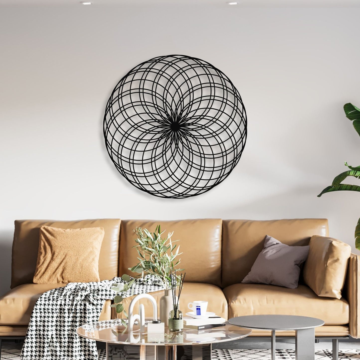 Modern living room with a brown leather sofa, decorative plant, and geometric wall art.