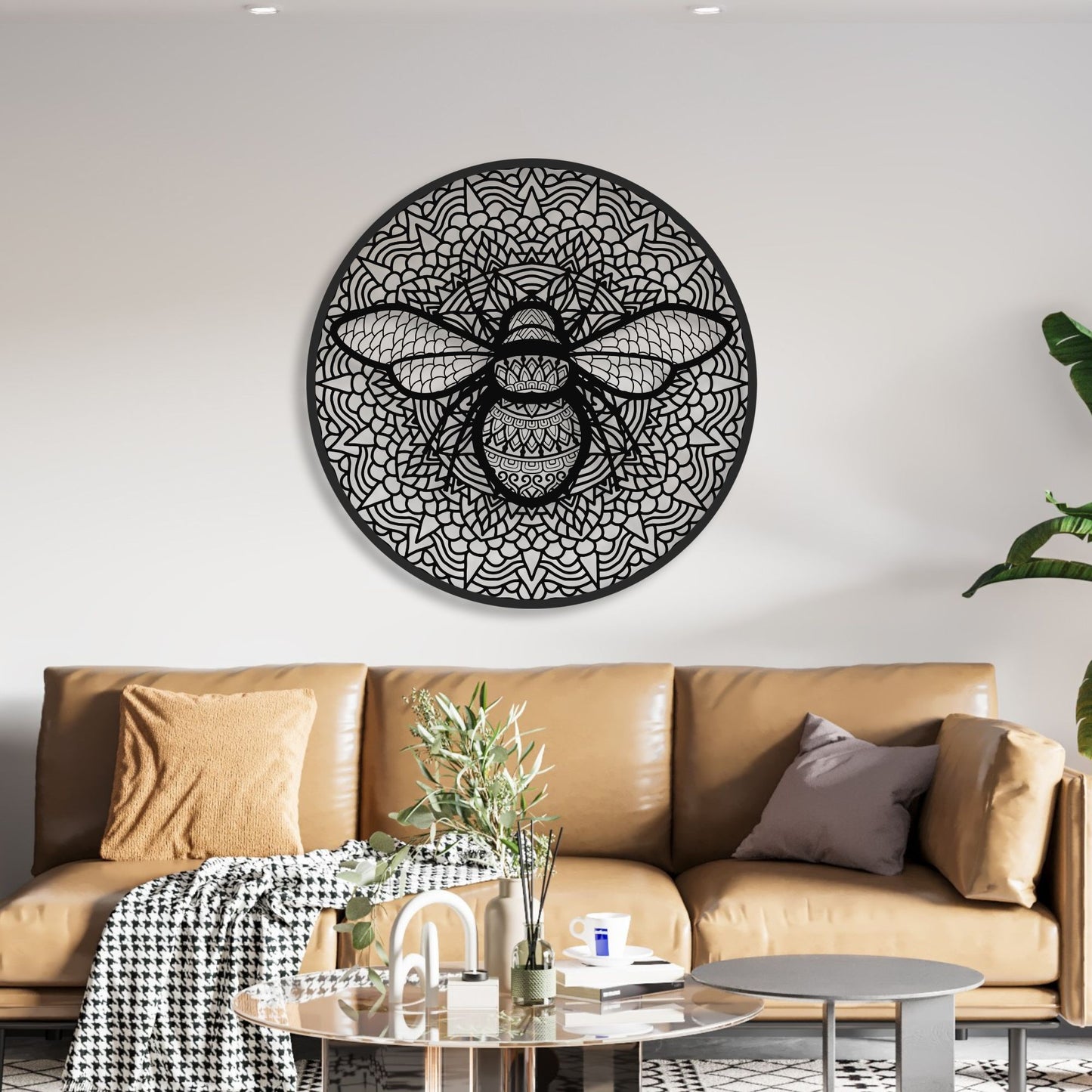 Decorative wall art of a bee on a white wall above a brown sofa.