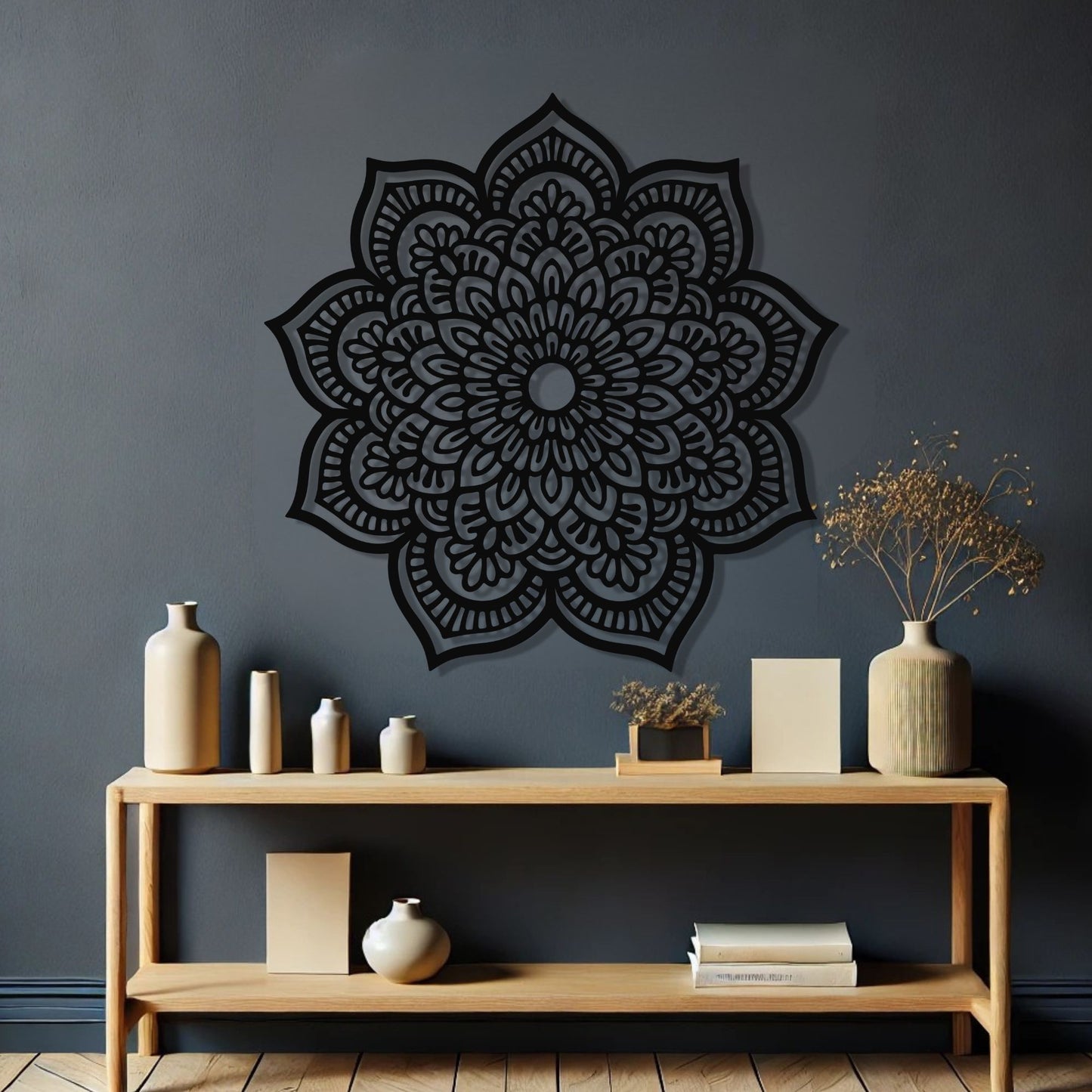 Decorative black mandala wall art on a dark gray wall with a wooden shelf below.