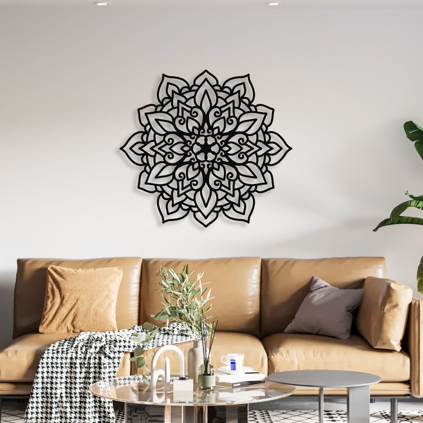 Decorative black mandala wall art on a white wall above a brown sofa.