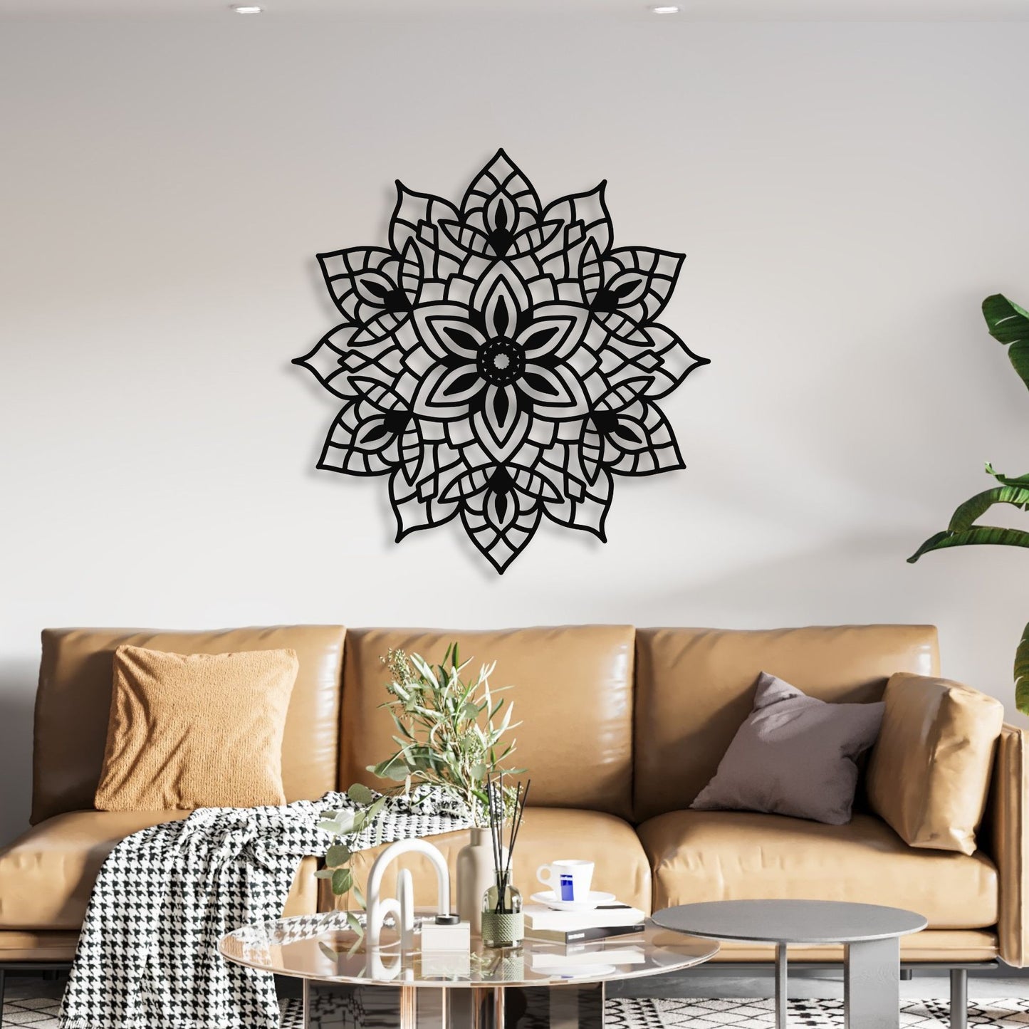 Decorative black wall mandala above a brown sofa in a living room.