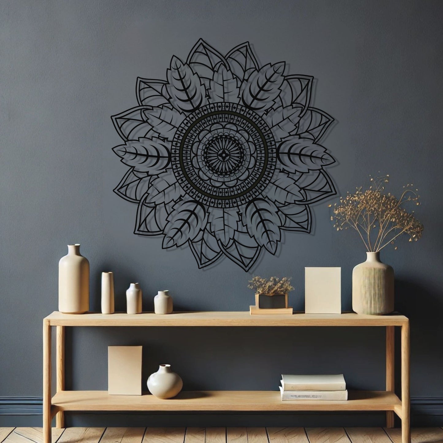 Decorative black mandala wall art on a dark gray wall with a wooden shelf below.