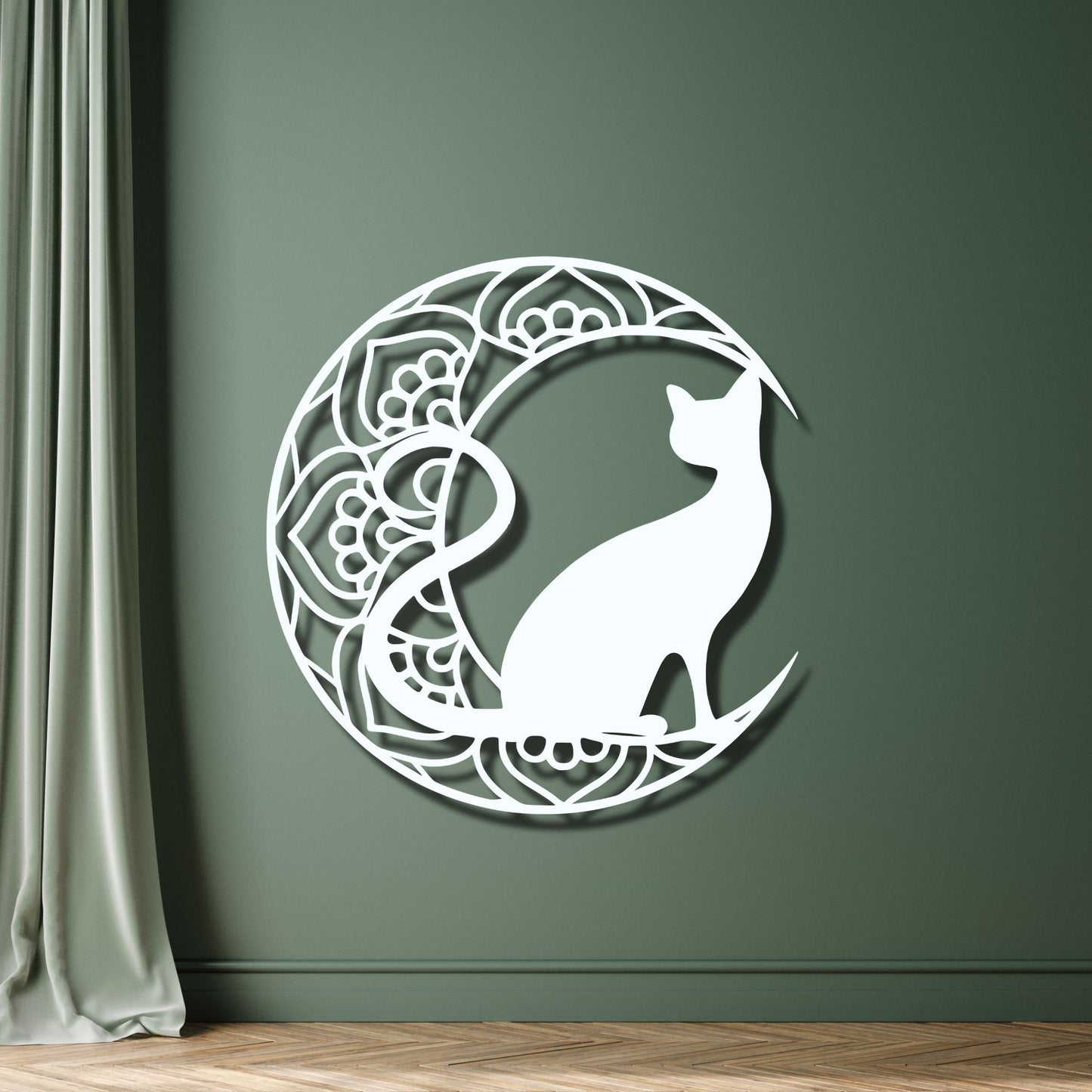 Decorative wall art of a cat on a crescent moon with mandala patterns against a green wall.