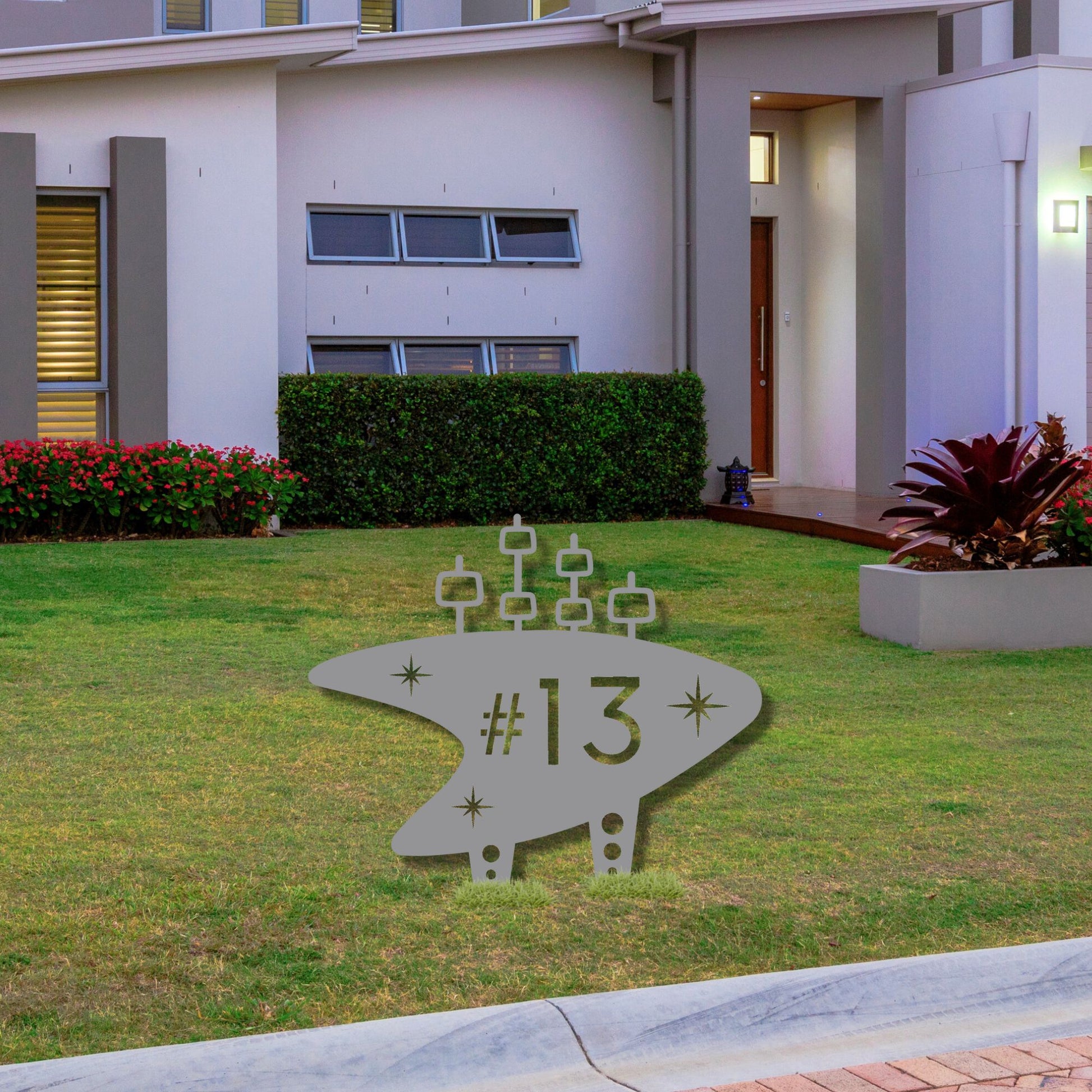 Modern house with a decorative metal address sign on a lawn