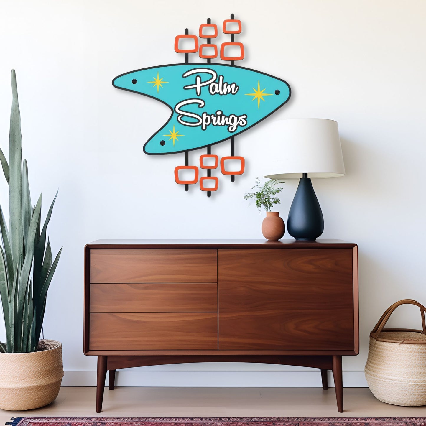 Decorative sign with 'Palm Springs' text above a wooden dresser with a lamp and plants.