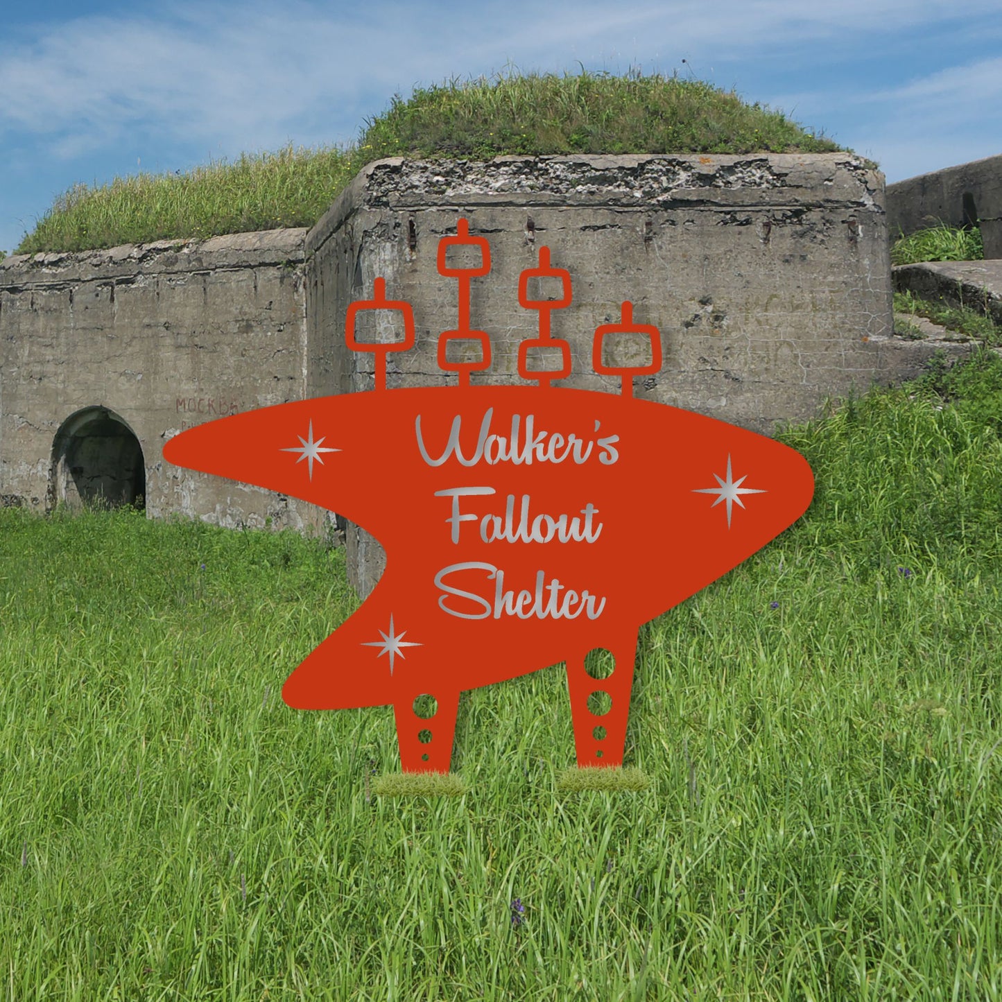 Orange 'Walker's Fallout Shelter' sign in front of a concrete bunker.