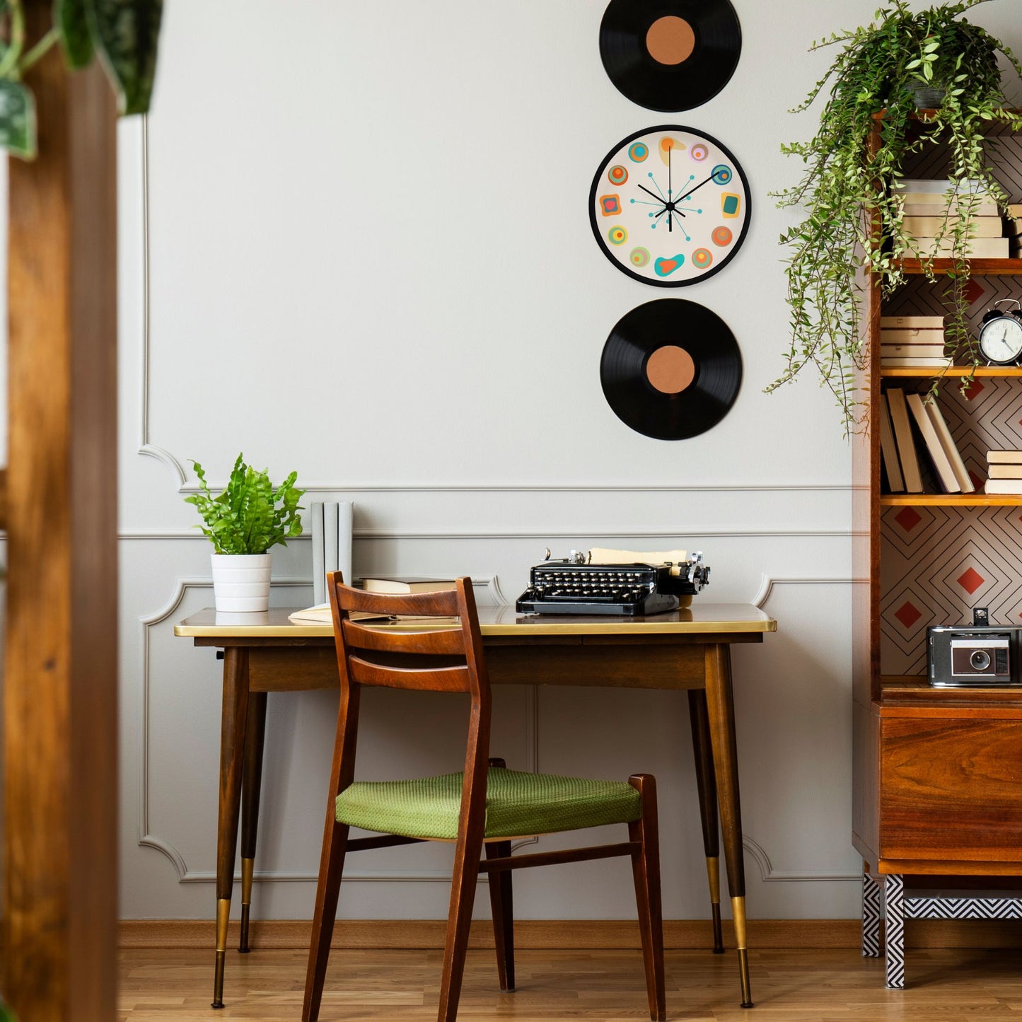 Dining area with wooden table, chairs, and decorative elements on a white wall.