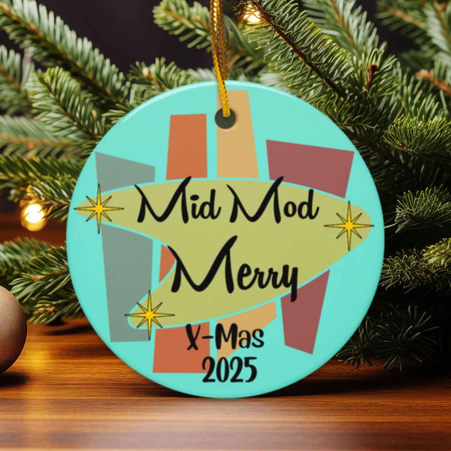 Circular Christmas ornament with 'Mid Mod Merry X-Mas 2025' text, hanging on a tree.