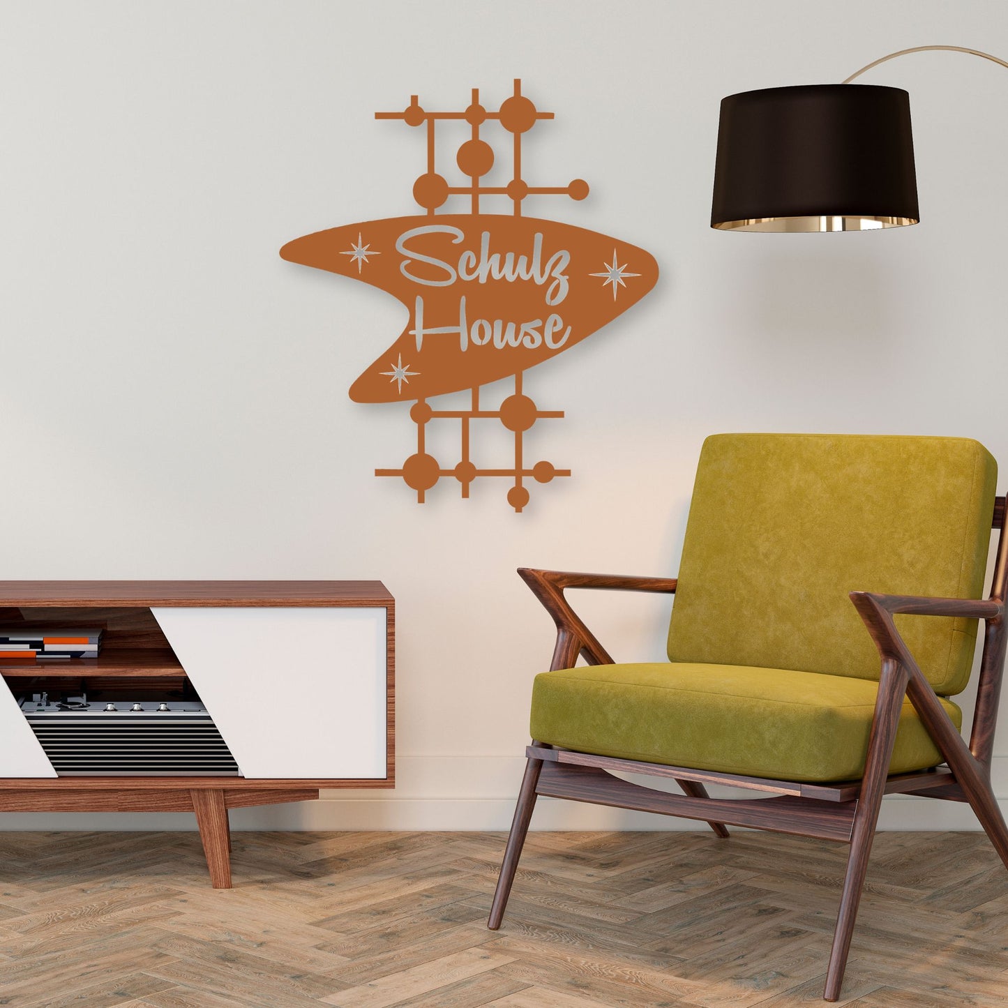 Modern living room with a green chair, wooden sideboard, and 'Schulz House' wall art.