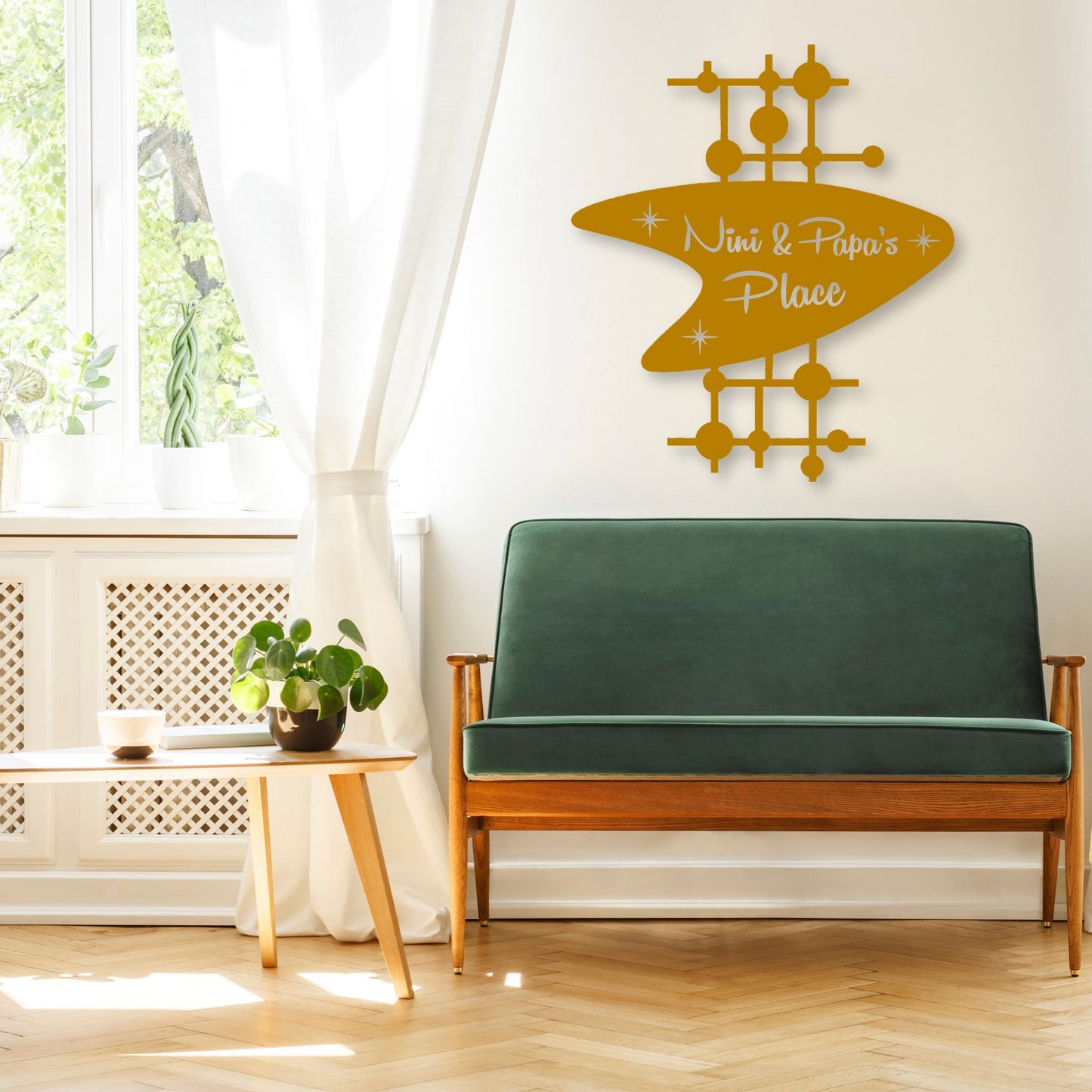 Green sofa in a living room with a decorative wall sign above it.
