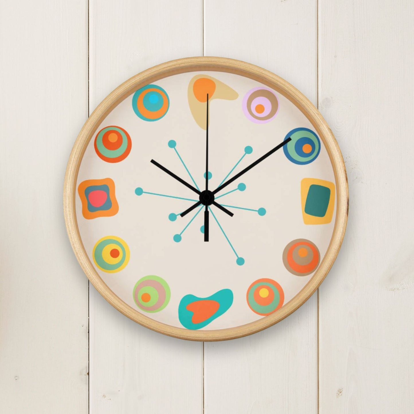 Colorful wall clock with abstract designs on a white wooden background