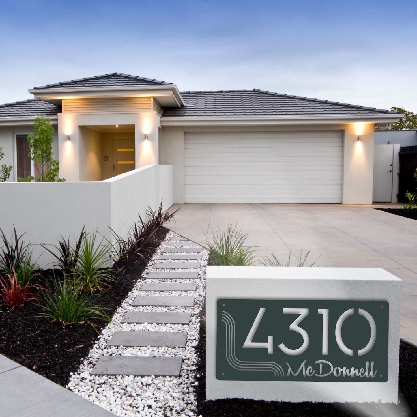 Modern house with a driveway and decorative house number sign.
