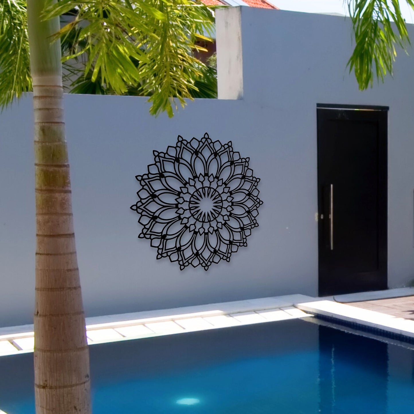 Lotus Flower Mandala Metal Wall Art shown in black hanging over a residential pool