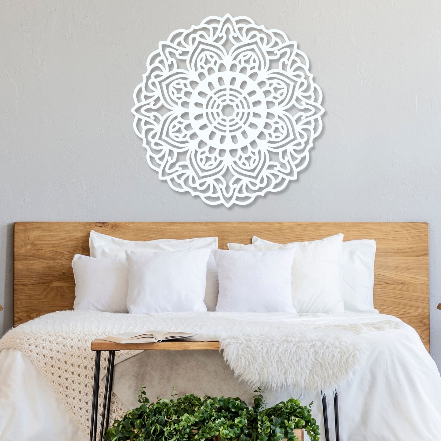 Decorative wall art above a bed with white bedding and wooden headboard.