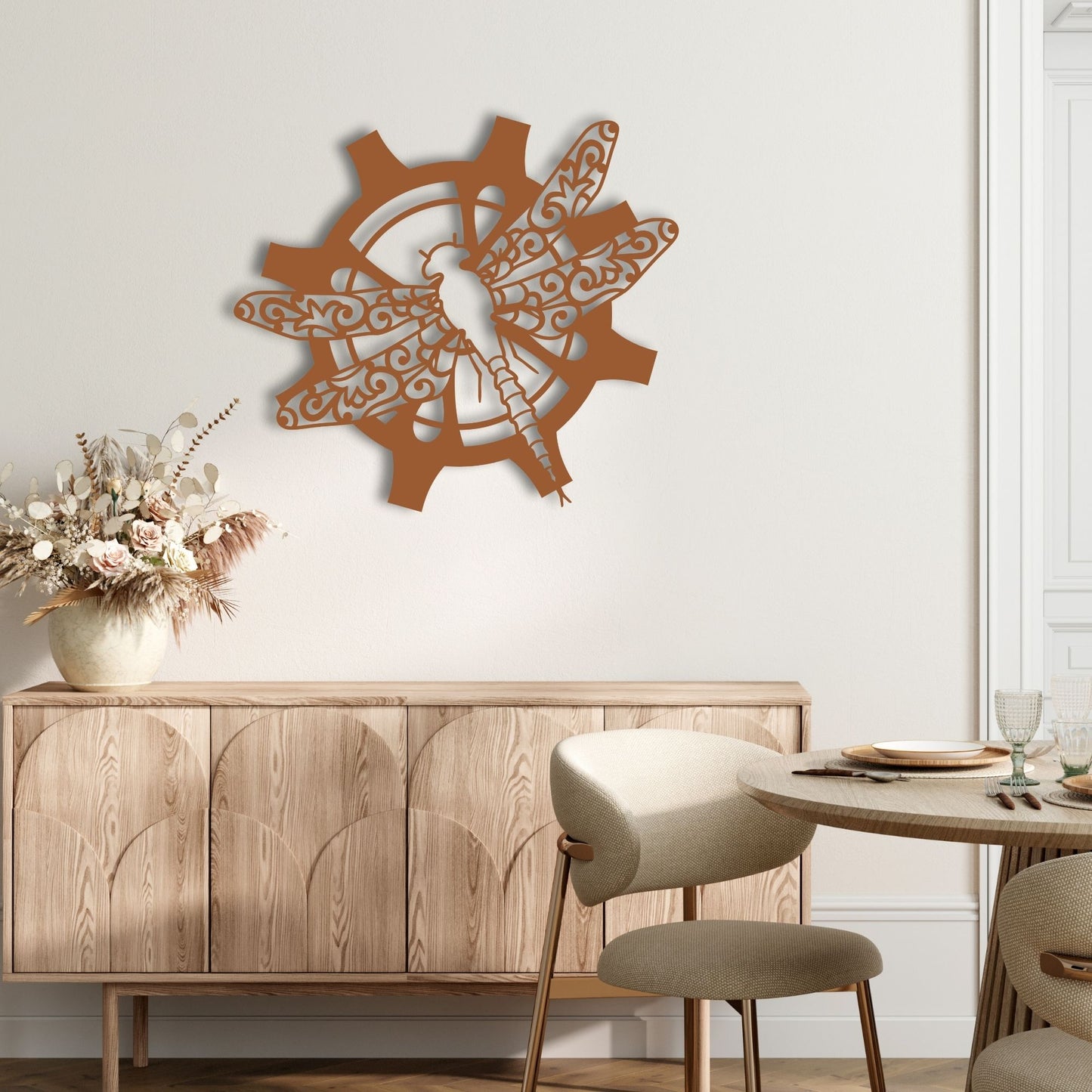 Decorative wall art with a dragonfly design above a wooden cabinet and table set.