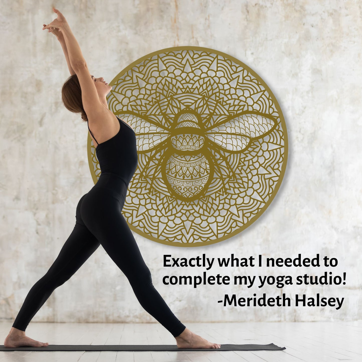 Woman in black yoga attire practicing yoga in front of a decorative wall panel with a bee design.