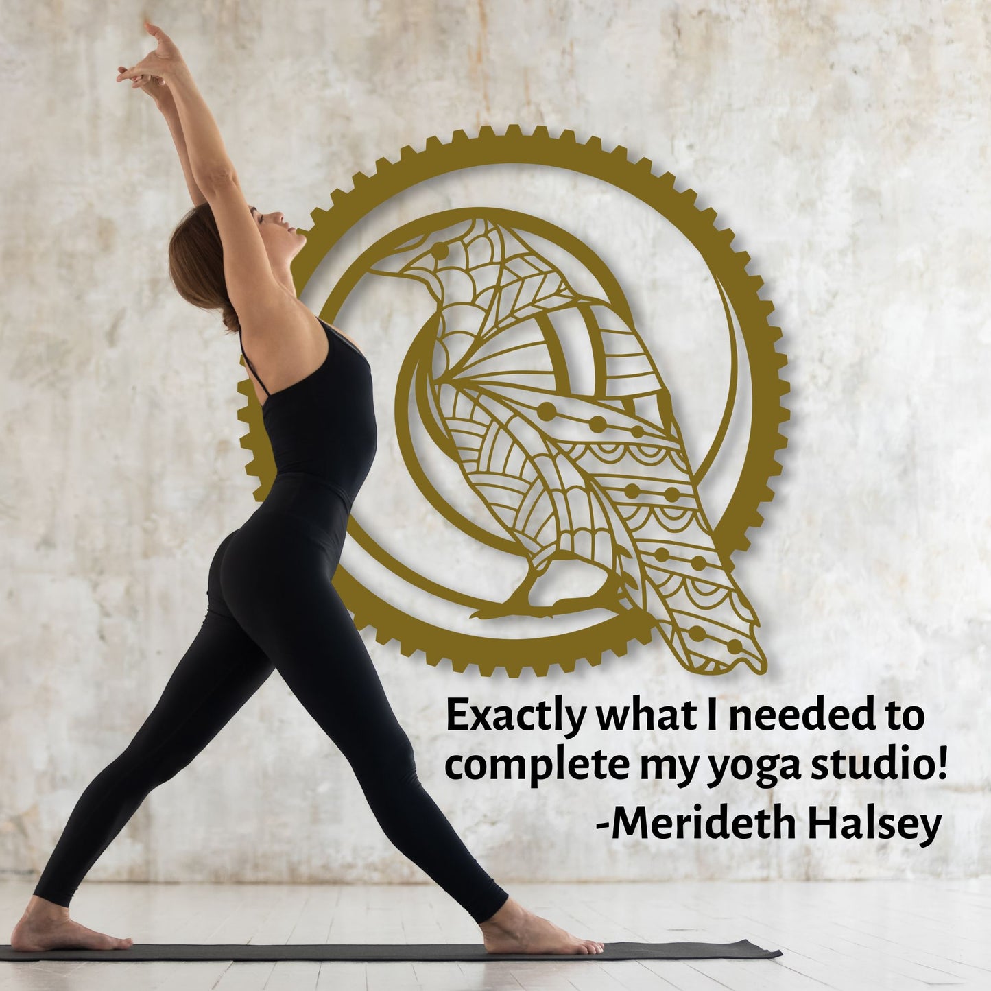 Woman in black yoga attire practicing yoga in front of a wall with a decorative gold logo.