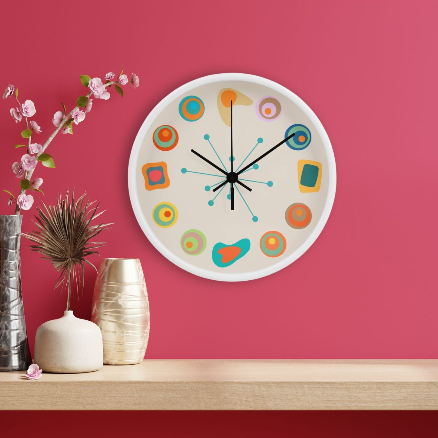 Colorful wall clock on a pink wall with decorative vases and flowers.