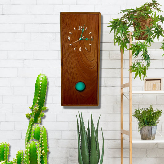 KingWood Pendulum Wall Clock In Cedar & Turquoise on white brick wall
