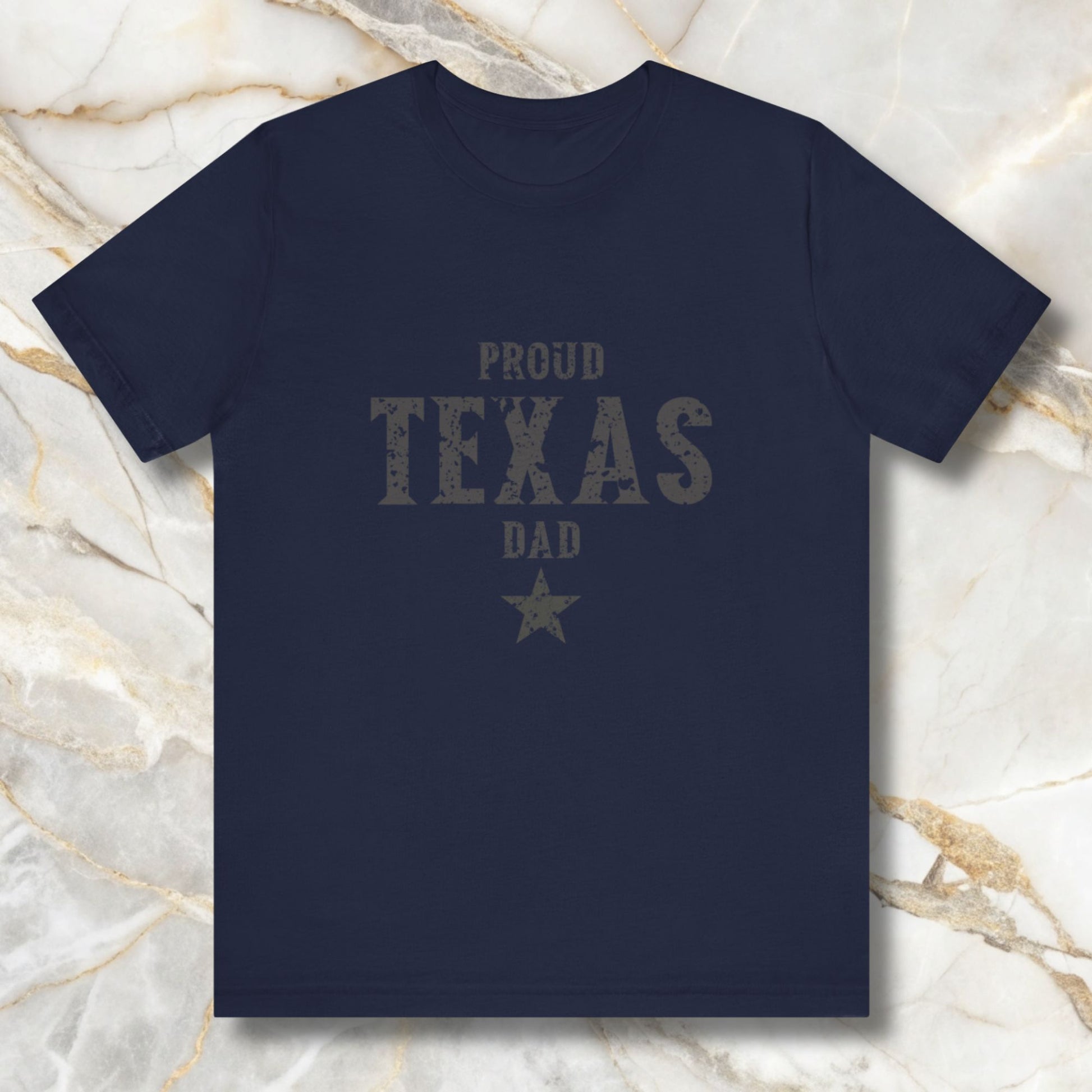 Navy blue t-shirt with 'Proud Texas Dad' text on a marble background