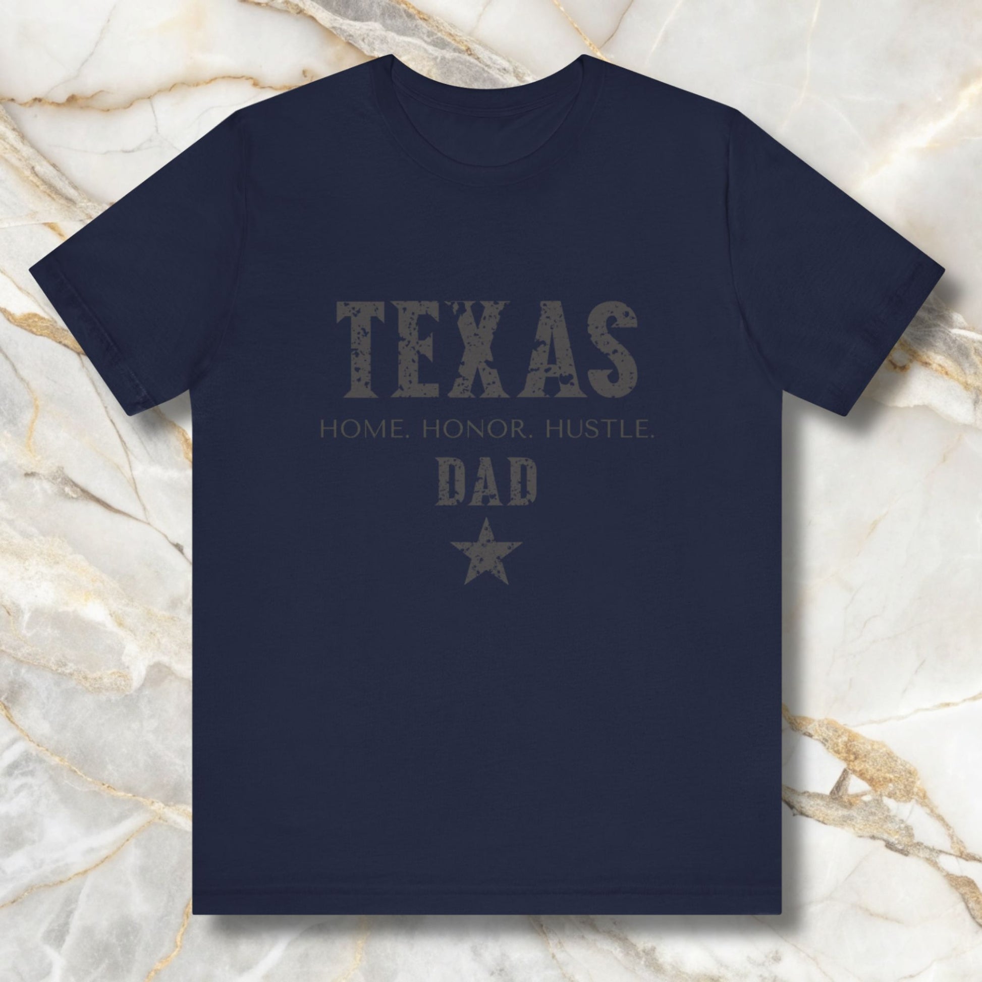 Navy blue t-shirt with 'Texas Dad' text on a marble background