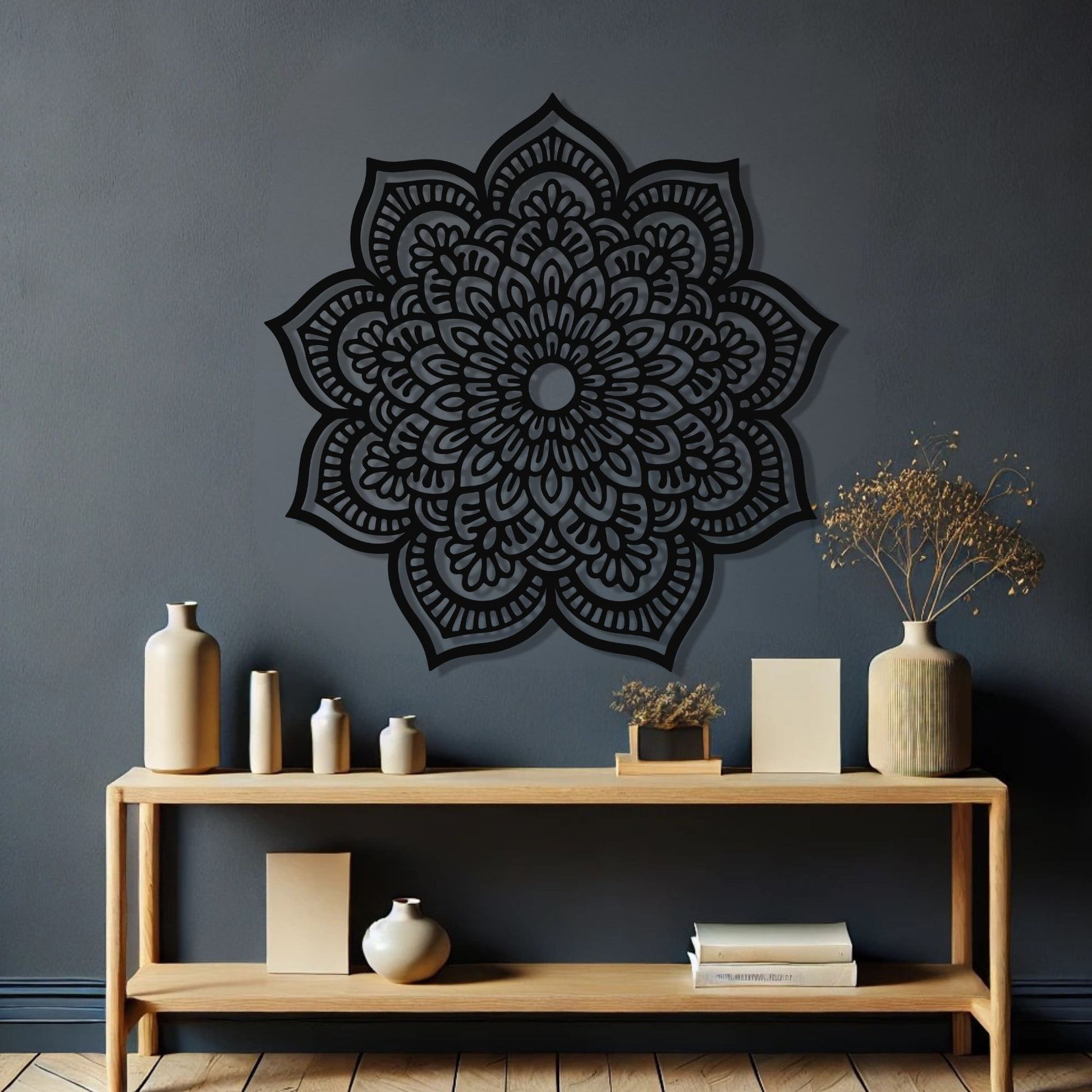 Decorative black mandala wall art on a dark gray wall with a wooden shelf below.