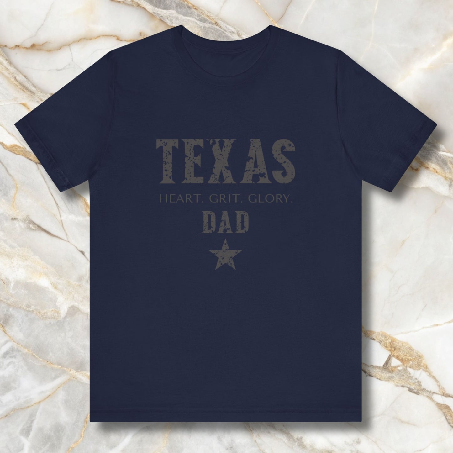 Navy blue t-shirt with 'Texas Dad' text on a marble surface