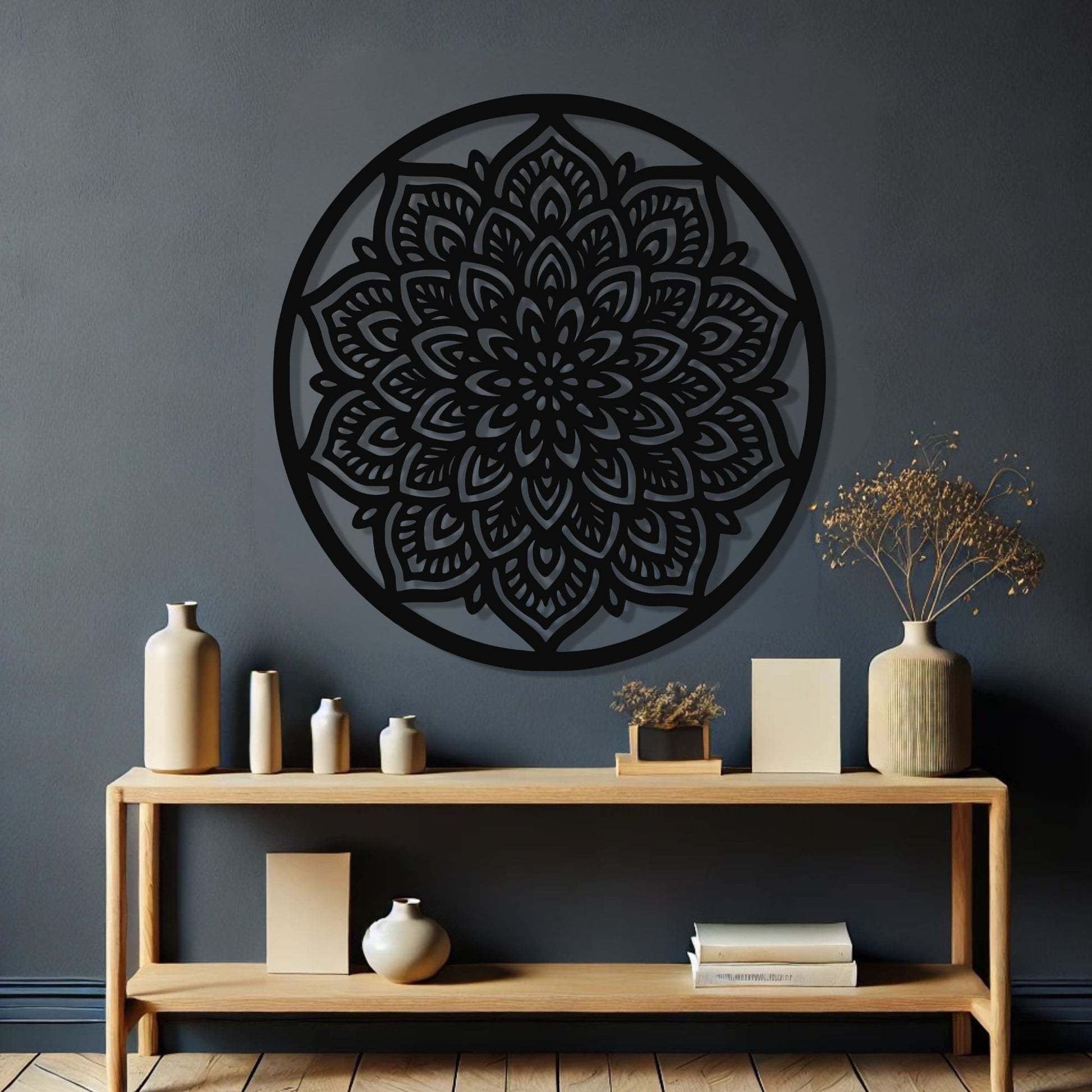 Decorative black mandala wall art on a dark gray wall with a wooden shelf below.