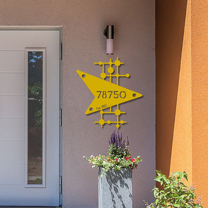 Yellow geometric design with numbers on a building exterior, next to a door and planters.