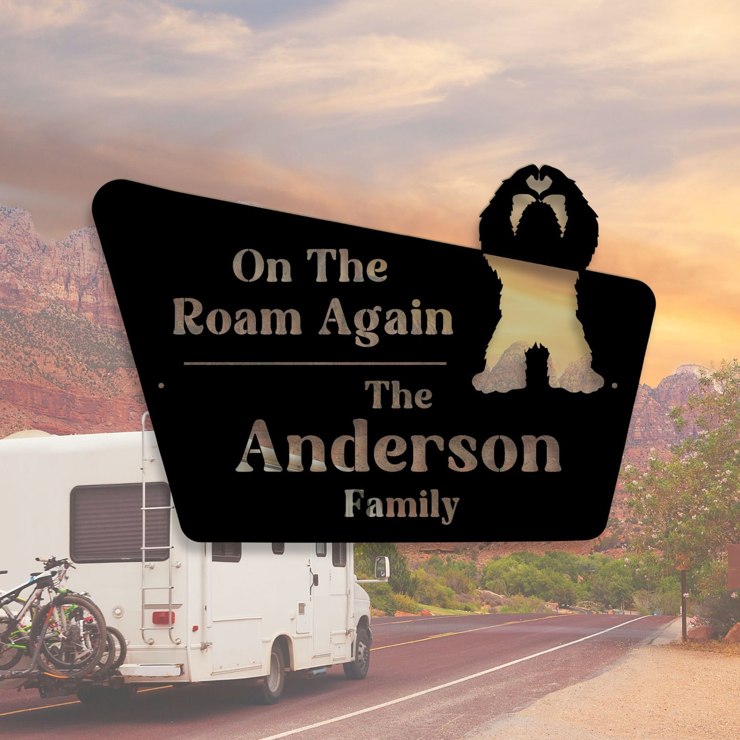 Personalized sign for an RV with 'On The Roam Again' and 'The Anderson Family' text, set against a scenic road backdrop.