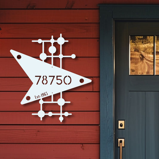 Decorative metal sign with '78750' on a red wooden wall next to a black door.
