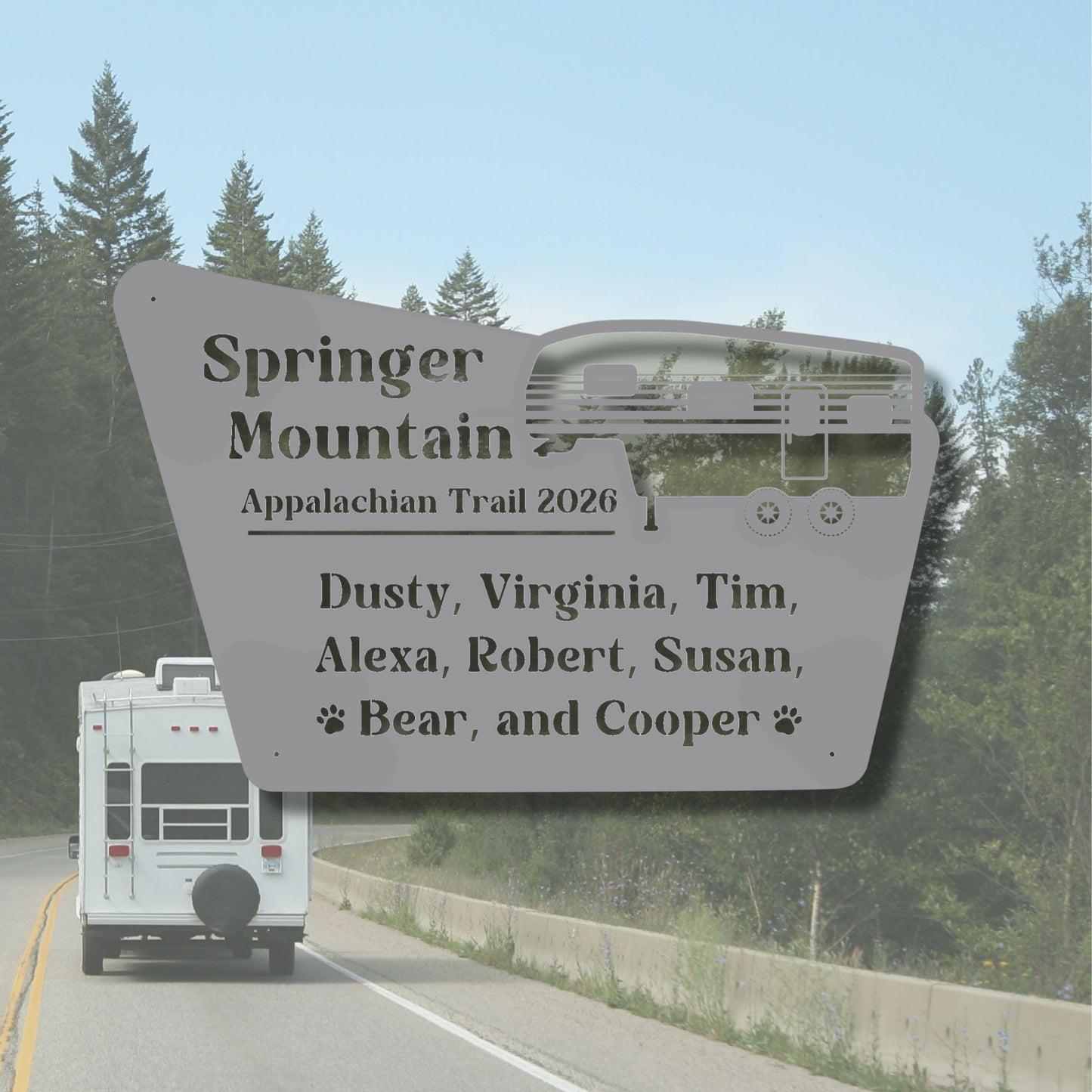 White RV on a road with a large sign listing names and 'Springer Mountain Appalachian Trail 2026' in the foreground.