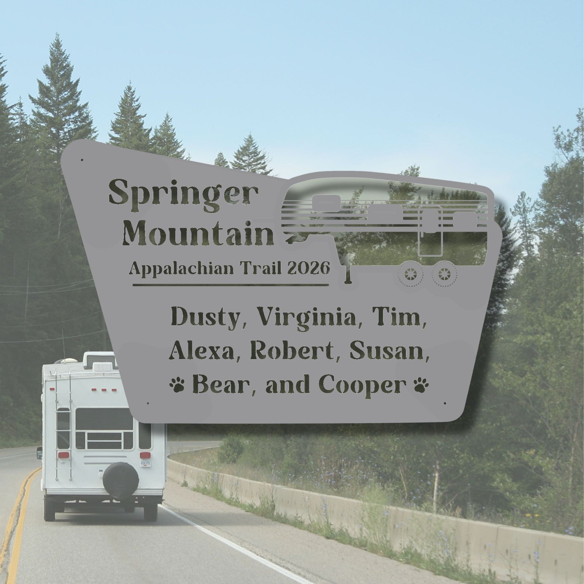 White RV on a road with a large sign listing names and 'Springer Mountain Appalachian Trail 2026' in the foreground.