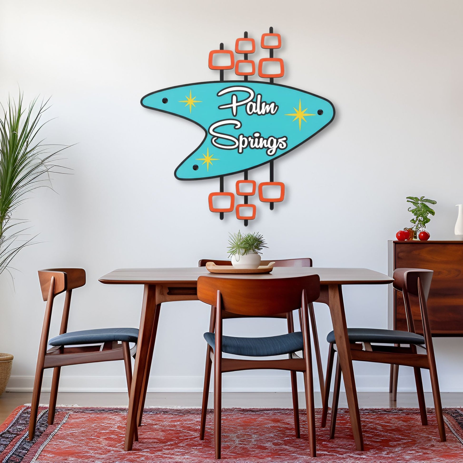 Dining room with a 'Palm Springs' wall art above a wooden table and chairs.
