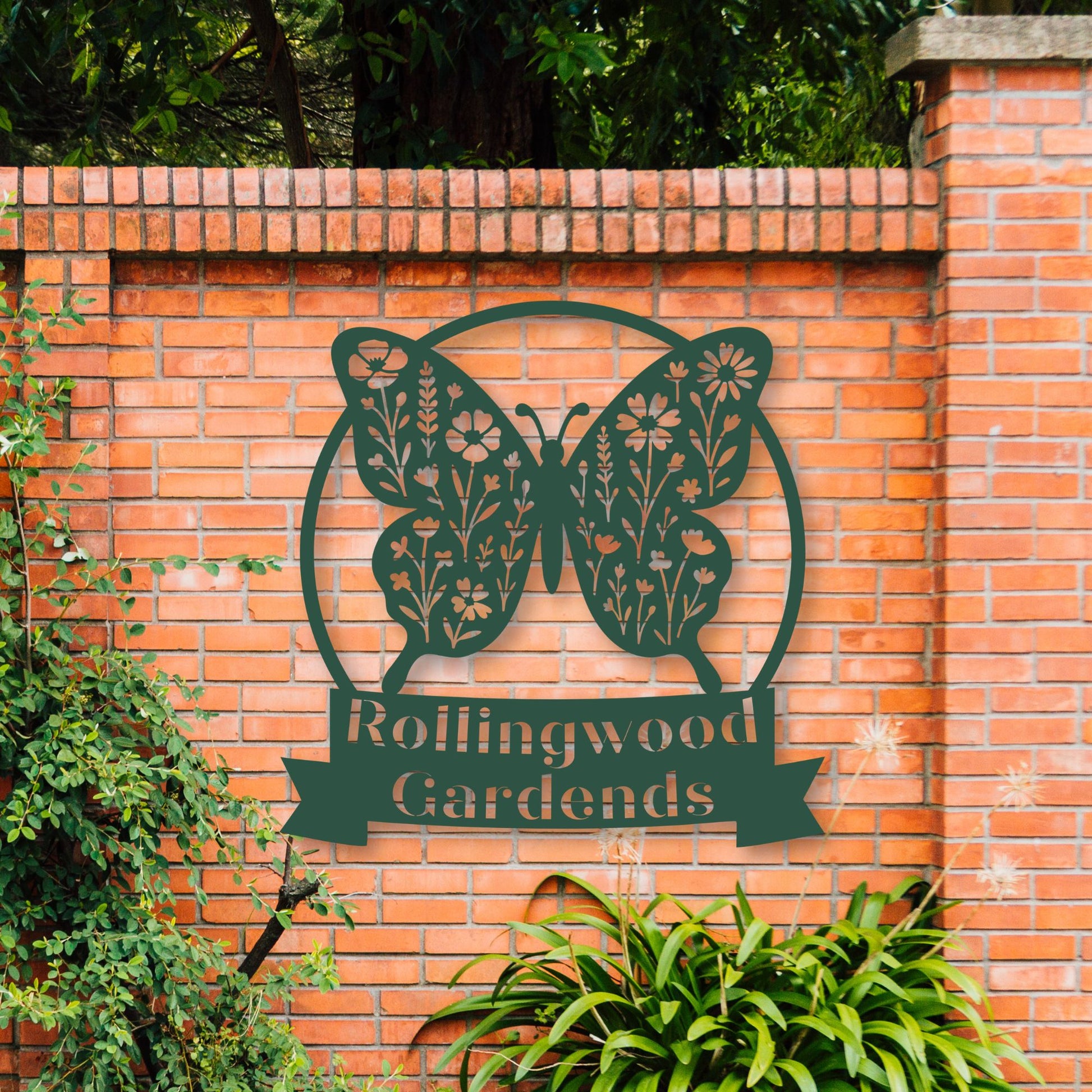 Butterfly-shaped sign with 'Rollingwood Gardens' on a brick wall.