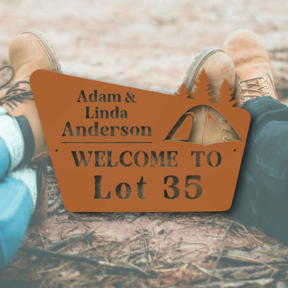 Personalized wooden sign with names and lot number, placed between feet on a natural ground.