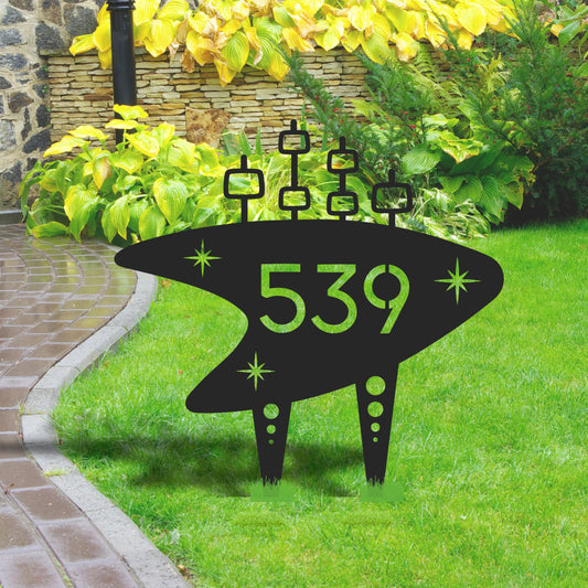  UFO-shaped decorative lawn sign with numbers on a grassy area