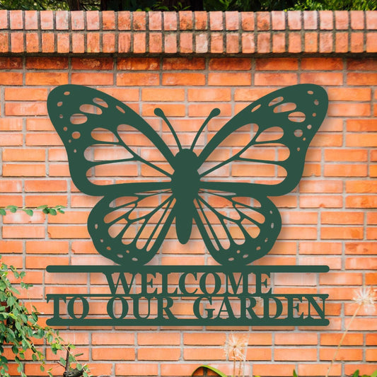 Butterfly-shaped metal sign with 'Welcome to our Garden' text on a brick wall.