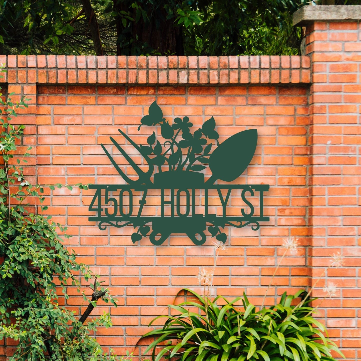 Metal address sign with decorative elements on a brick wall