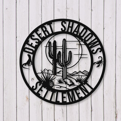 Decorative wall art with cactus design and 'Desert Shadows Settlement' text on a wooden background