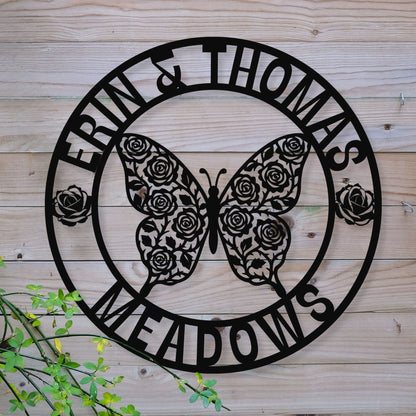 Decorative metal sign with butterfly and floral design on a wooden background