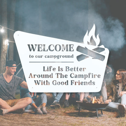 People sitting around a campfire with a sign welcoming them to the campground and emphasizing the enjoyment of time with friends.