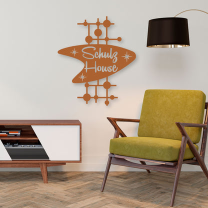 Modern living room with a green chair, wooden sideboard, and 'Schulz House' wall art.