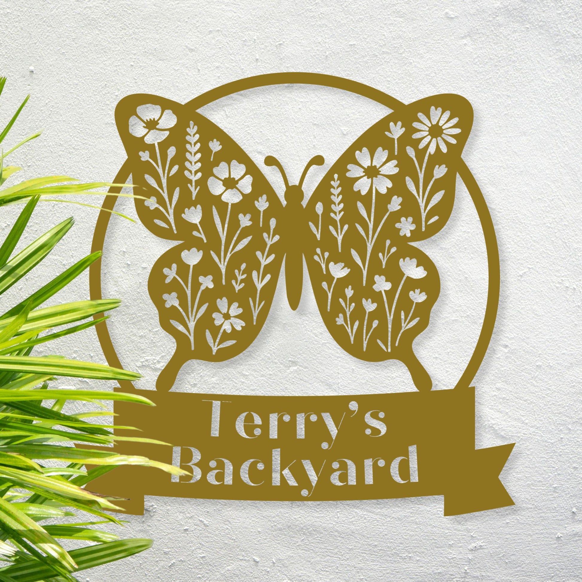 Decorative metal sign with butterfly design and 'Terry's Backyard' text on a textured surface.