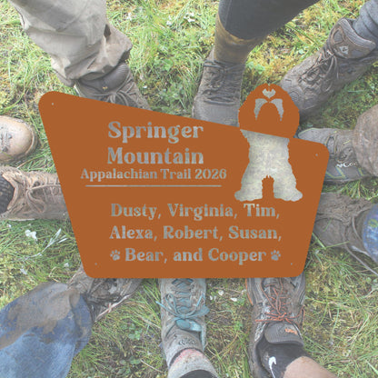 Hiking boots around a sign for Springer Mountain Appalachian Trail 2020 with names listed.