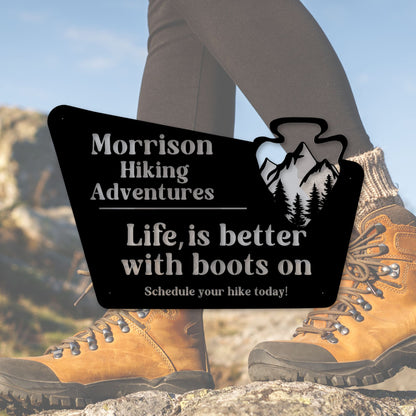 Hiking boots with a promotional sign for Morrison Hiking Adventures.