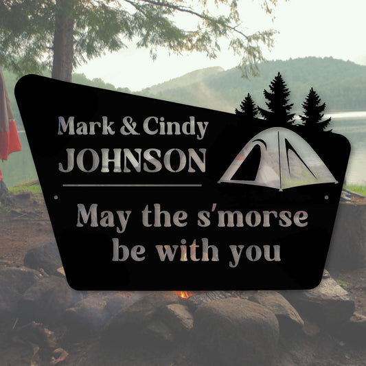 Personalized metal sign with camping design and text in a campsite setting.