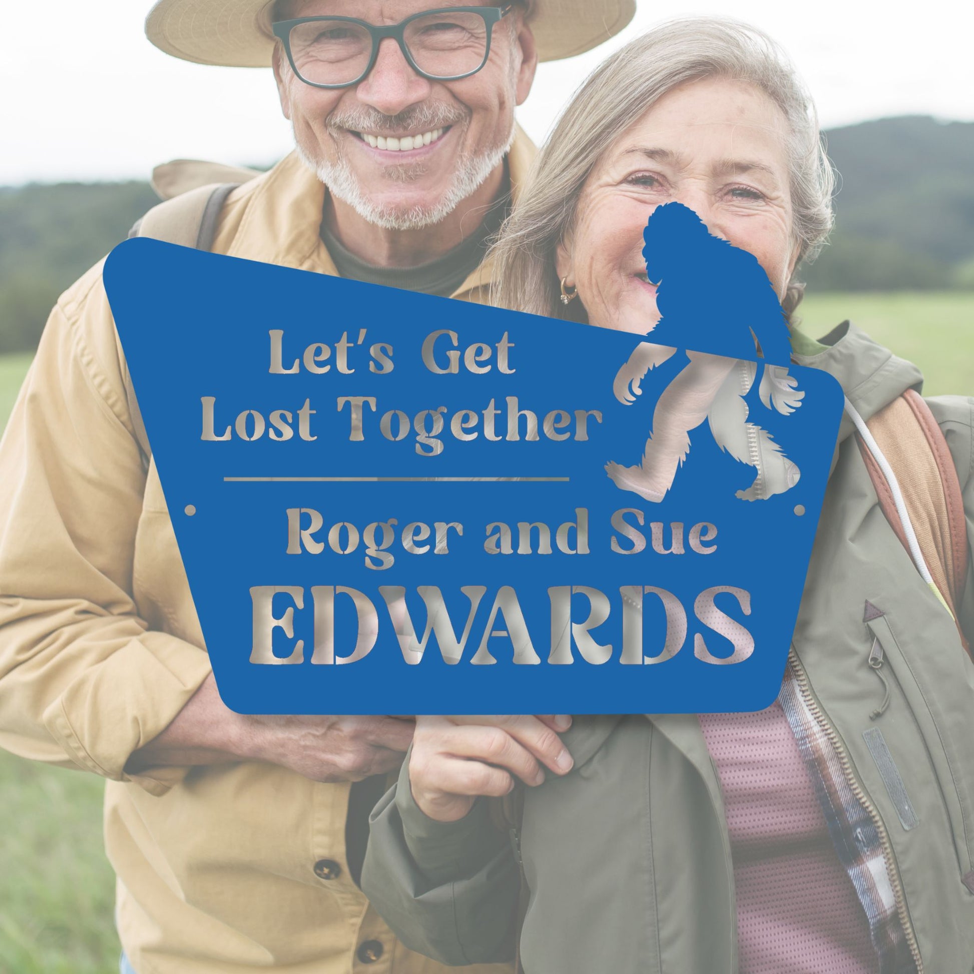 Two people holding a blue sign with text and a bear graphic, standing outdoors.